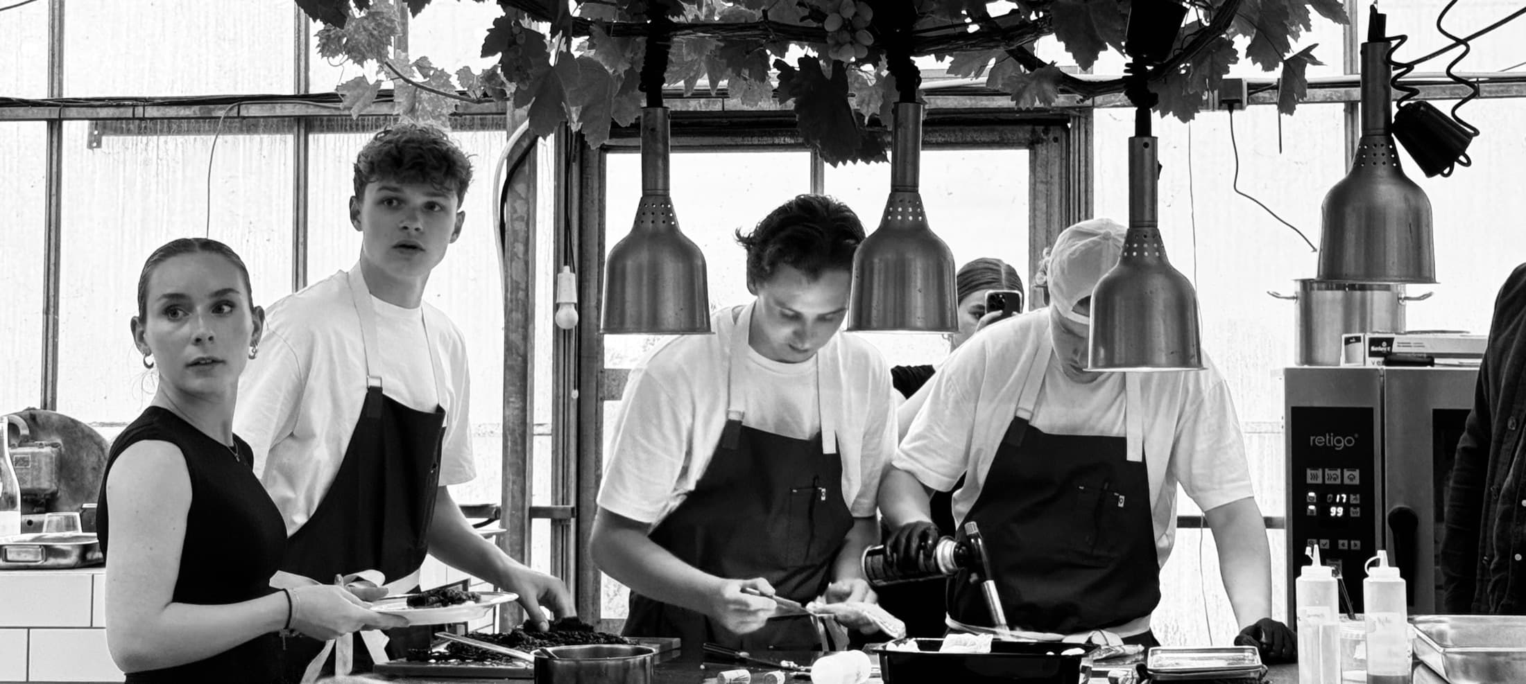 Het team van Festin aan het werk onder de warmtelampen in een professionele keuken